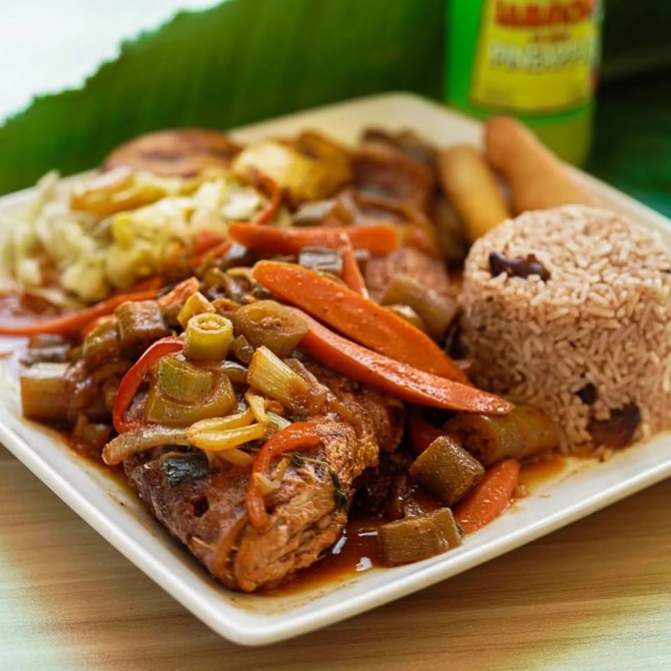 Fish with vegetables, rice and peas and plantain.