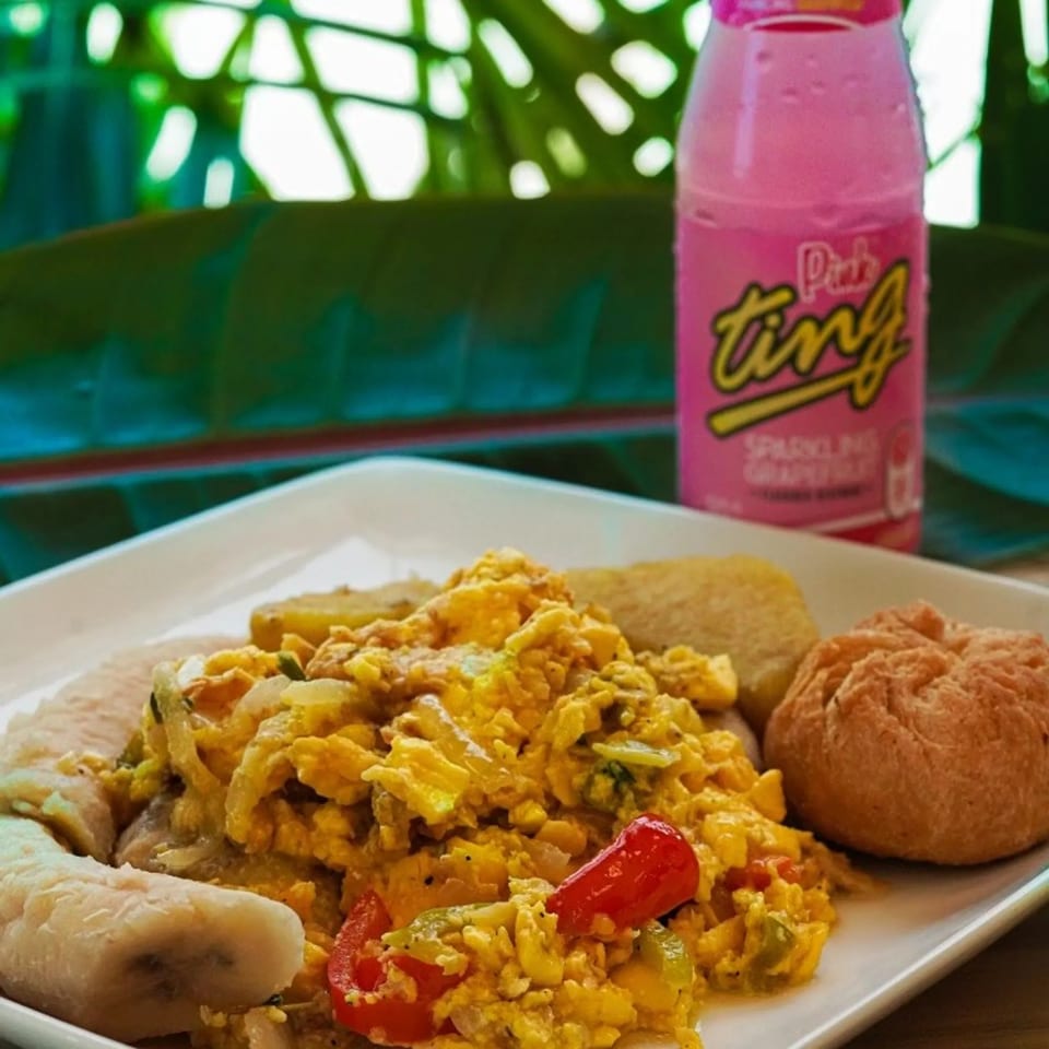 Jamaican breakfast plate with ackee and saltfish and Pink Ting.