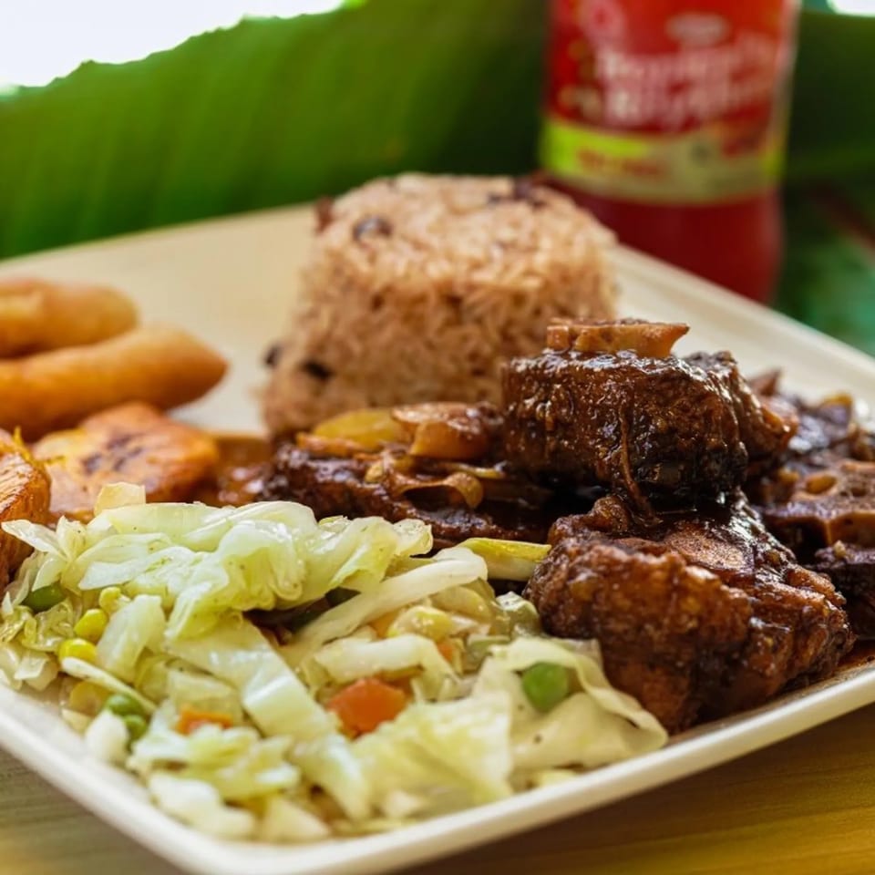 Oxtail with rice and peas, cabbage and fried dumplings.