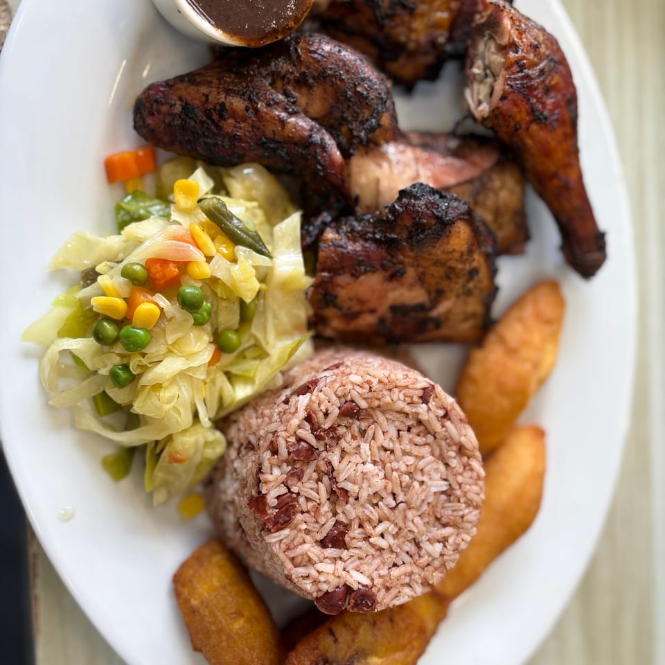 Overhead jerk chicken platter with rice and peas and plantain.